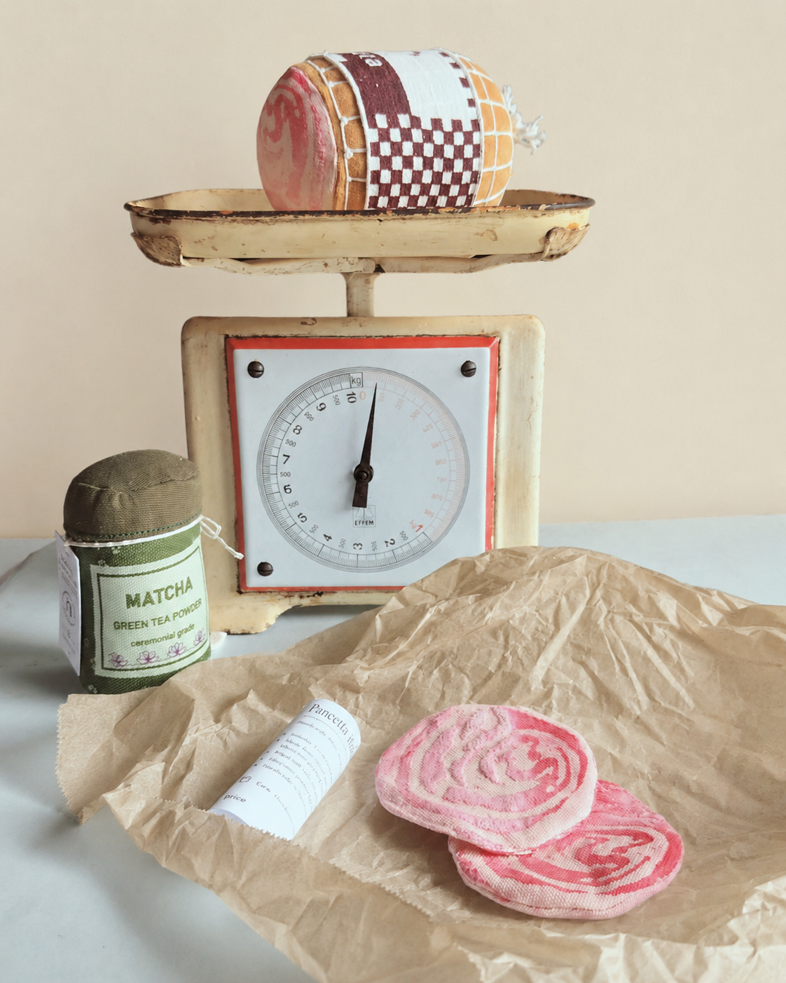 Vintage scale with a Play food  fabric rolled pancetta and matcha green tea powder on a light background