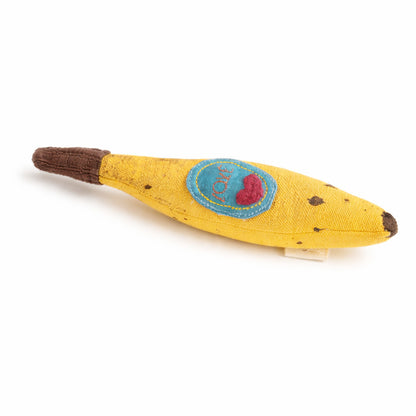 Yellow baby rattle toy resembling a banana with a blue patch and red heart on a white background
