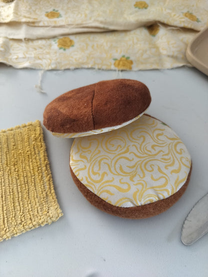 Handmade BMO play food shown open, featuring two soft brown fabric bun halves, yellow patterned cotton lining and a removable textured cheese slice.