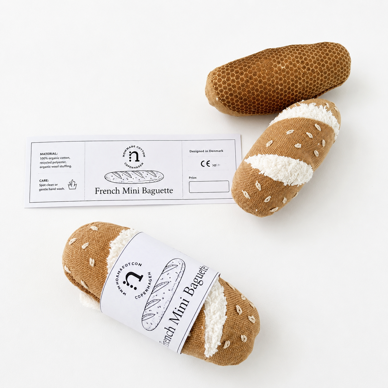 Three plush baguettes with a label on a white background