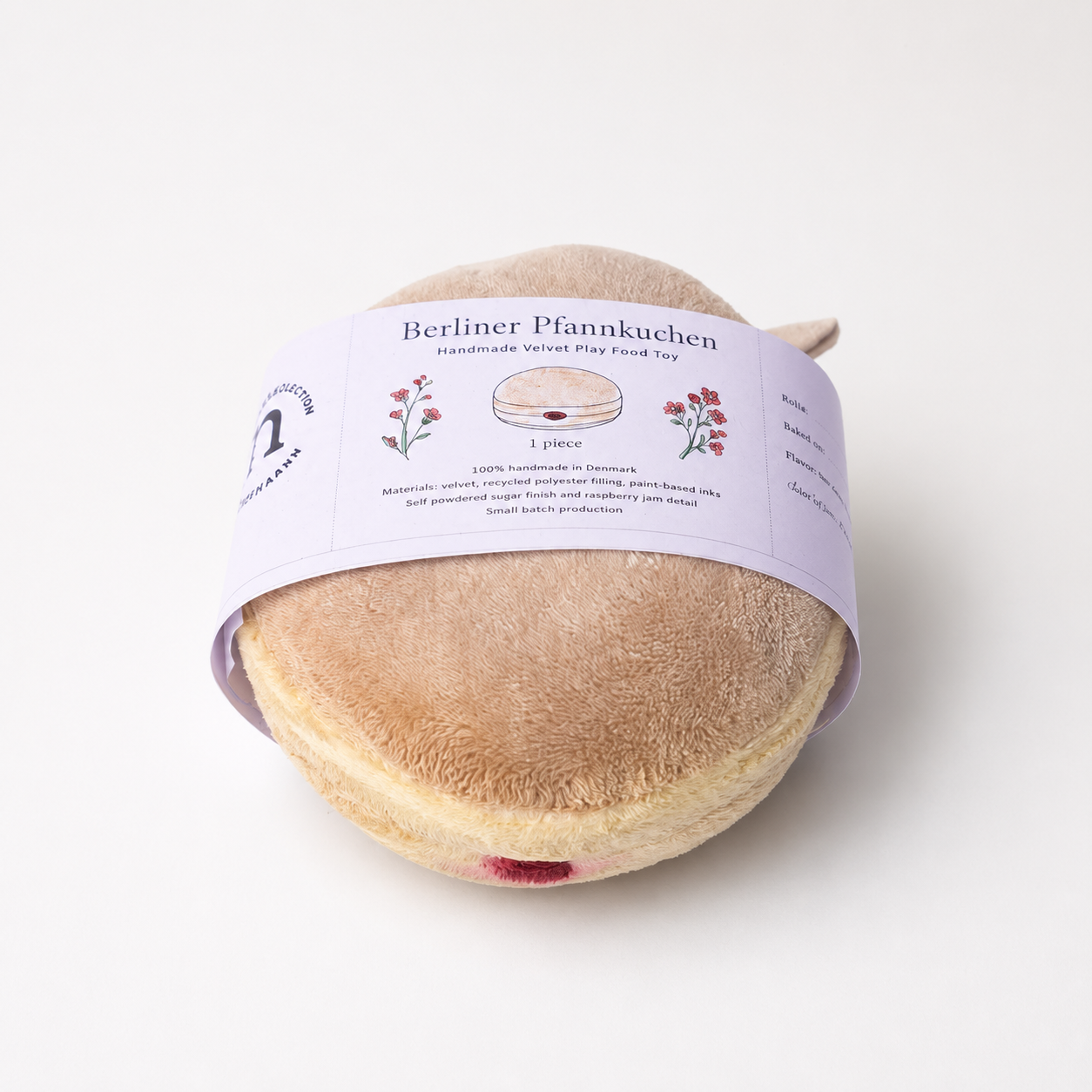 Handmade Berliner Pfannkuchen velvet play food toy with raspberry jam detail and illustrated paper band
