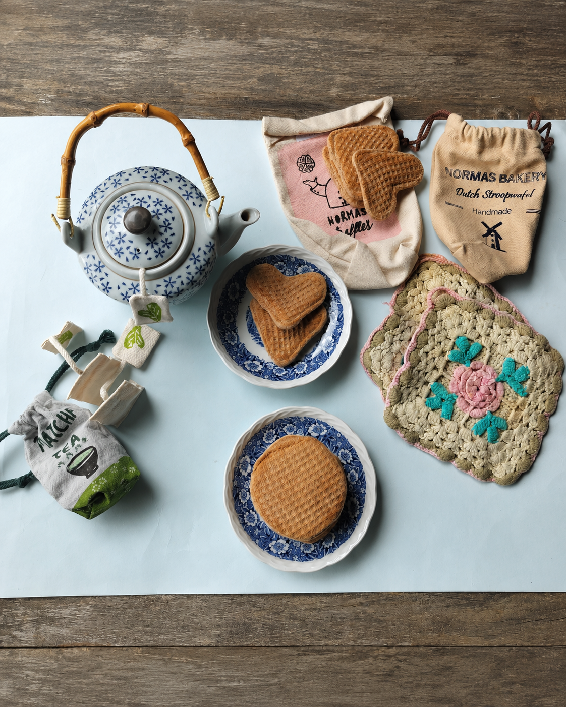 Handmade Dutch stroopwafel play food arranged with a vintage teapot, plates, matcha tea set and crocheted placemats